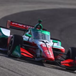 Fotografía de acción longitudinal de un monoplaza de IndyCar de Prema Racing con decoración italiana tricolor roja, blanca y verde, número 9, circulando rápidamente por una curva peraltada de un circuito de asfalto. Los logotipos de 'PREMA' son visibles en los alerones trasero y delantero. Se distinguen logotipos de 'DNSFilter' en el endplate delantero y Chevrolet en el pontón lateral.