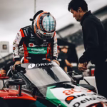 Piloto Takuma Sato entrando al cockpit de su auto IndyCar con aeroscreen en pits