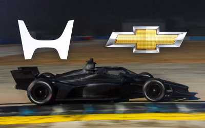 Logotipos de Honda y Chevrolet sobre un monoplaza IndyCar negro en pista de pruebas.