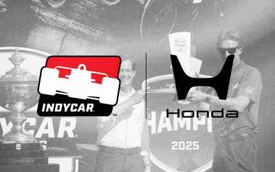 Logotipo de IndyCar junto al nuevo emblema de Honda sobre una imagen de fondo de una celebración de campeonato en 2025 con trofeos.